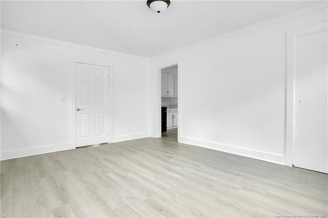 unfurnished living room with crown molding and light wood-type flooring