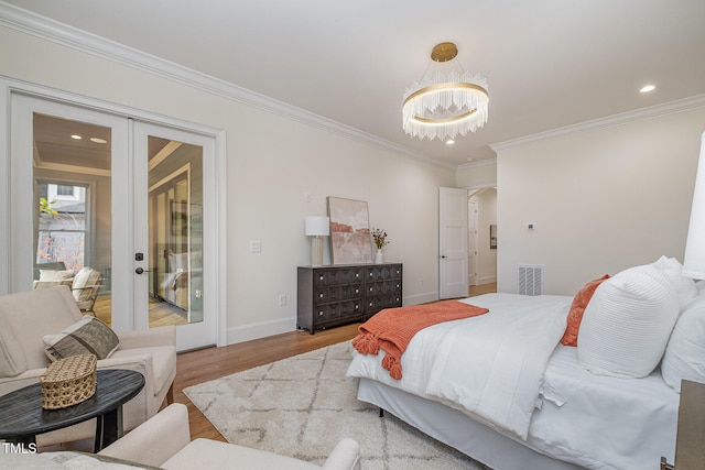 bedroom featuring access to outside, ornamental molding, light hardwood / wood-style floors, a notable chandelier, and french doors