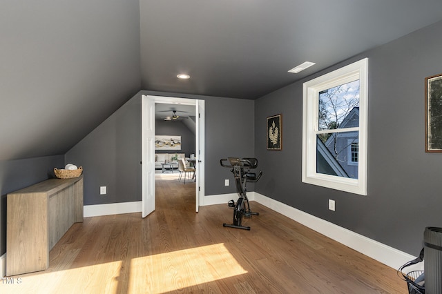 workout area with light hardwood / wood-style floors, lofted ceiling, and ceiling fan