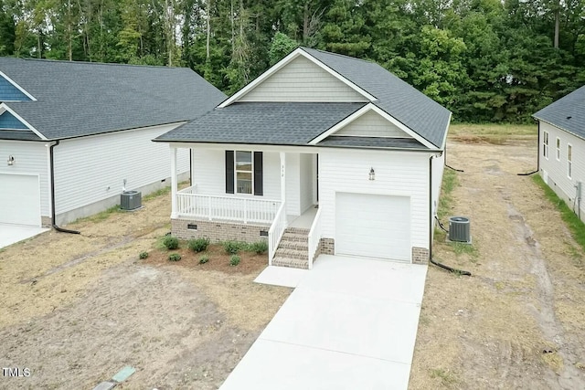 view of front of property featuring covered porch, central AC unit, and a garage