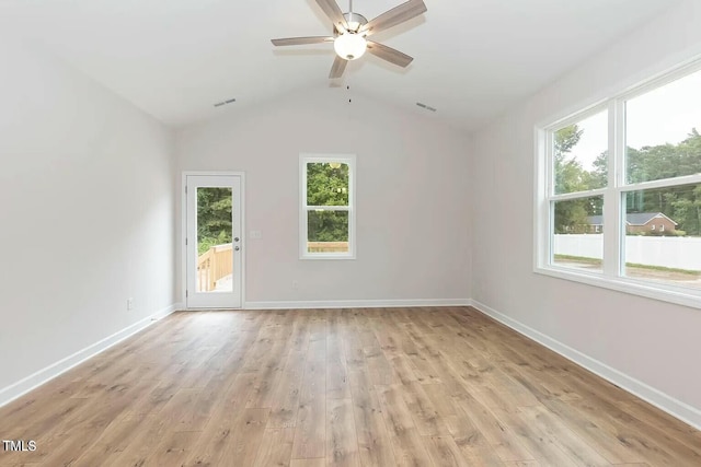 spare room featuring vaulted ceiling, light hardwood / wood-style flooring, a wealth of natural light, and ceiling fan