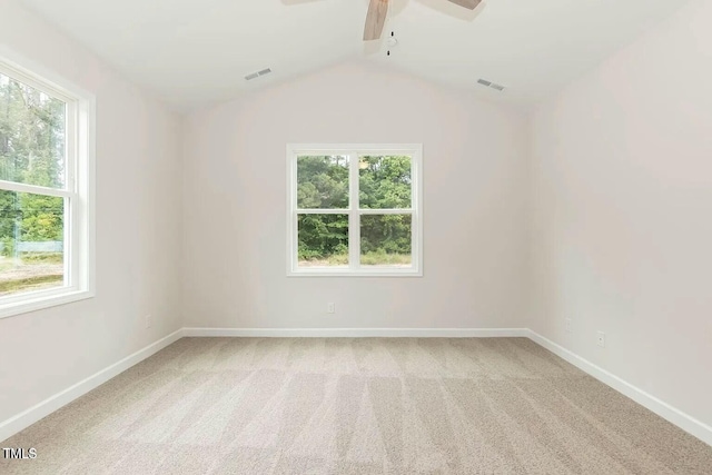 carpeted empty room featuring vaulted ceiling, a wealth of natural light, and ceiling fan