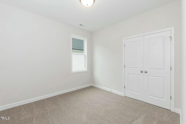 unfurnished bedroom featuring carpet floors and a closet