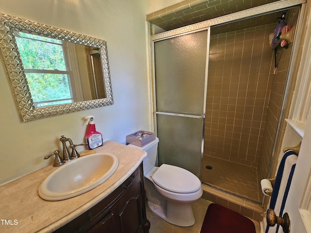 bathroom featuring a shower with shower door, vanity, and toilet