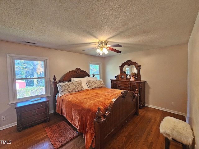 bedroom with a textured ceiling, dark wood-type flooring, and ceiling fan