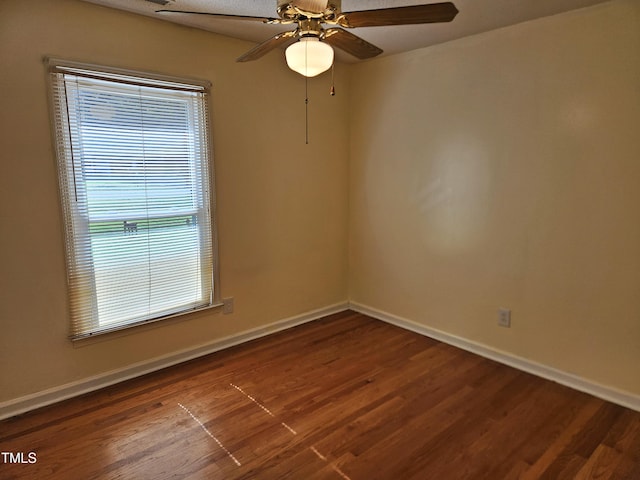 empty room with ceiling fan and dark hardwood / wood-style floors