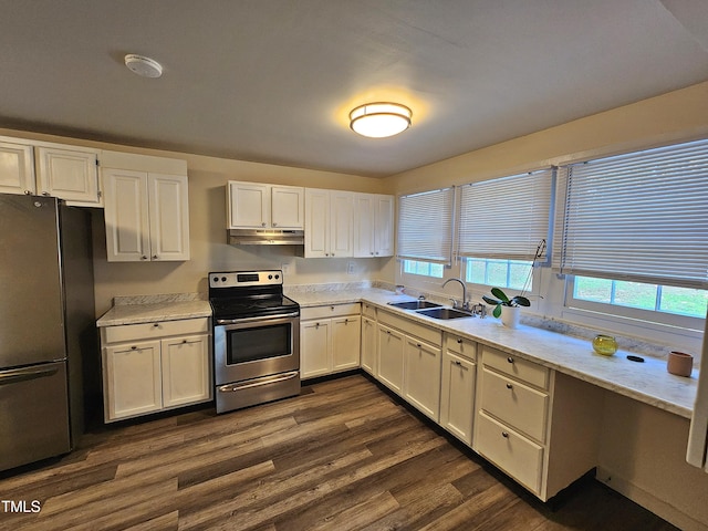 kitchen with light stone counters, white cabinets, sink, dark hardwood / wood-style floors, and appliances with stainless steel finishes