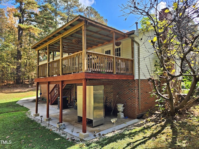 back of property with a deck, central air condition unit, a yard, and a patio area