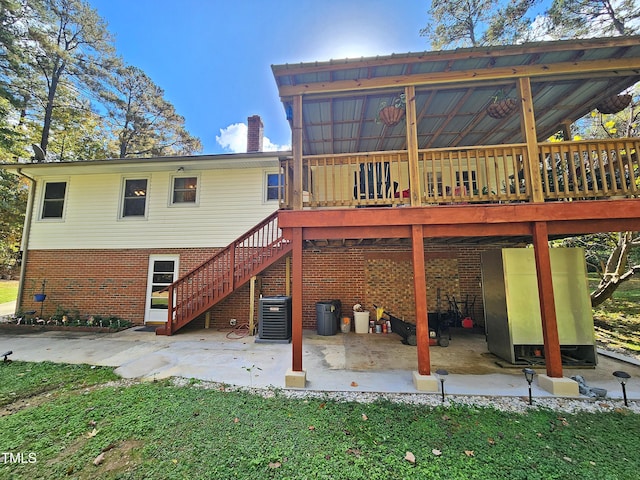 rear view of house featuring central air condition unit, a deck, and a patio area