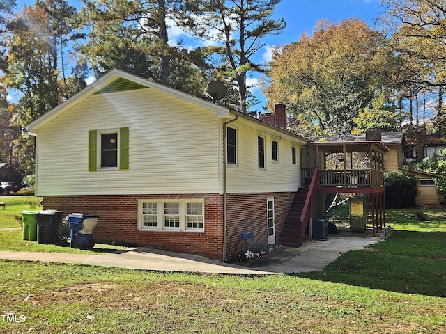 exterior space with central AC unit and a lawn