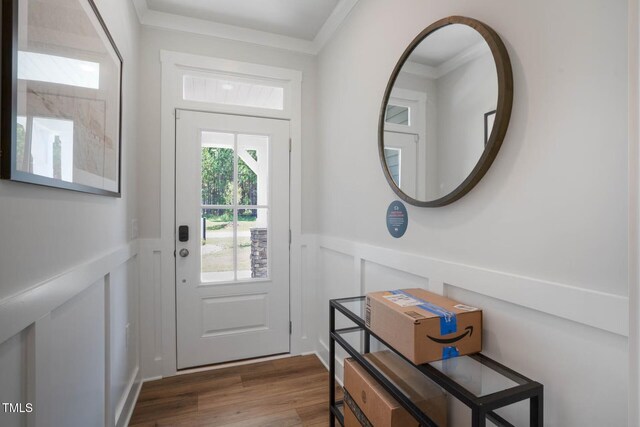 doorway with hardwood / wood-style floors and ornamental molding