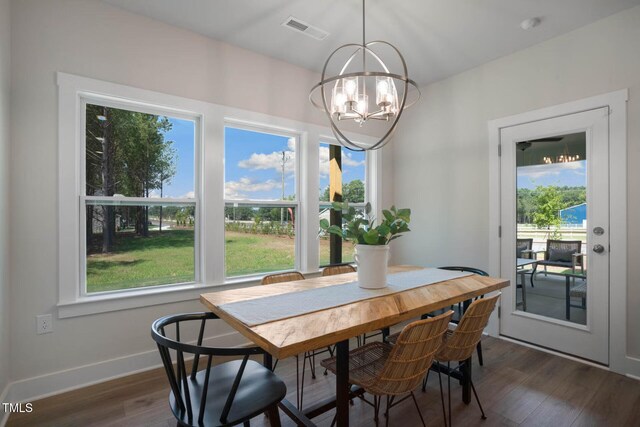 dining space with a notable chandelier, a wealth of natural light, and dark hardwood / wood-style floors