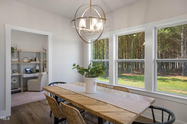 dining room with a healthy amount of sunlight, an inviting chandelier, and dark hardwood / wood-style flooring