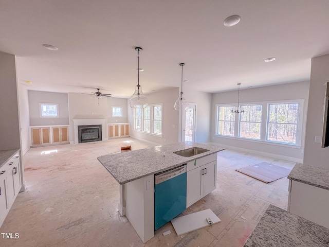 kitchen with dishwashing machine, light stone counters, white cabinetry, pendant lighting, and a kitchen island with sink