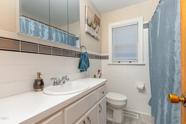 bathroom featuring wood-type flooring, vanity, toilet, and tile walls