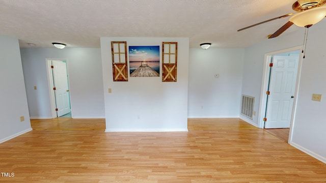 unfurnished room with light wood-type flooring, a textured ceiling, and ceiling fan