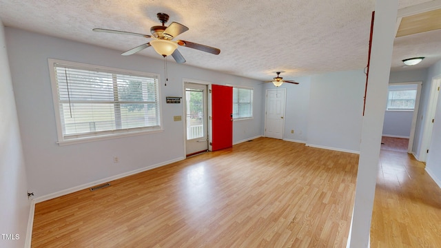 interior space featuring a wealth of natural light, a textured ceiling, and light hardwood / wood-style flooring