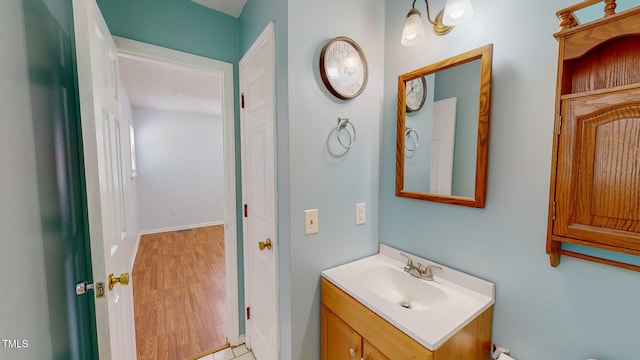 bathroom with hardwood / wood-style floors, vanity, and a textured ceiling