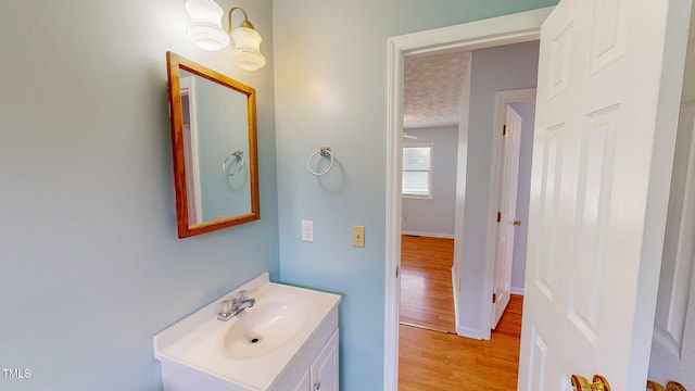 bathroom featuring hardwood / wood-style floors, vanity, and a textured ceiling