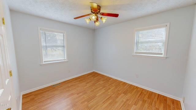 spare room featuring a textured ceiling, ceiling fan, and light hardwood / wood-style flooring