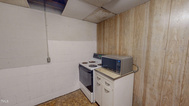 kitchen featuring wood walls and white electric stove