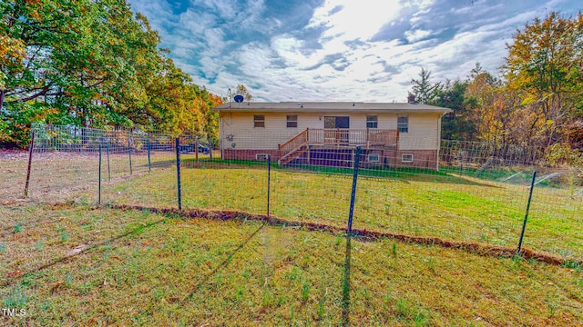 rear view of property featuring a lawn and a wooden deck