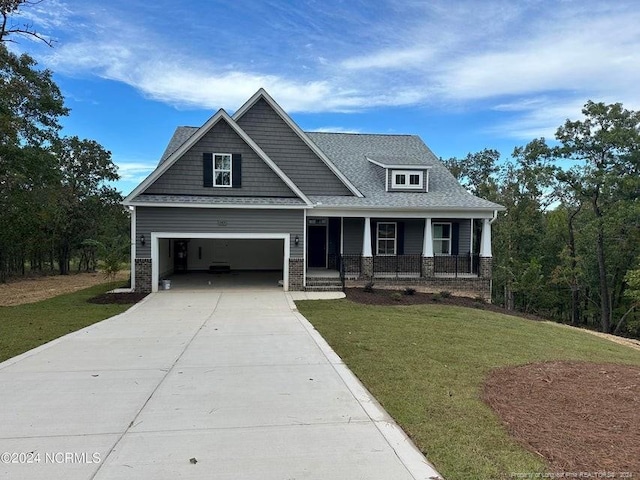 craftsman-style home with a front yard, covered porch, and a garage