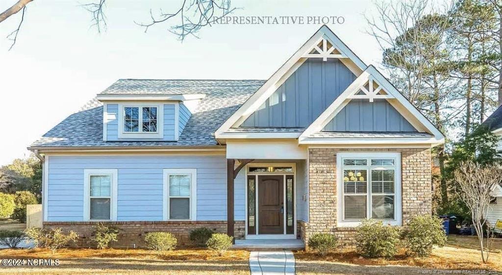200 Longleaf Dr, West End, NC 27376 - view of front of house featuring board and batten siding, brick siding, and a shingled roof
