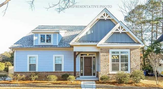 200 Longleaf Dr, West End, NC 27376 - view of front of house featuring board and batten siding, brick siding, and a shingled roof