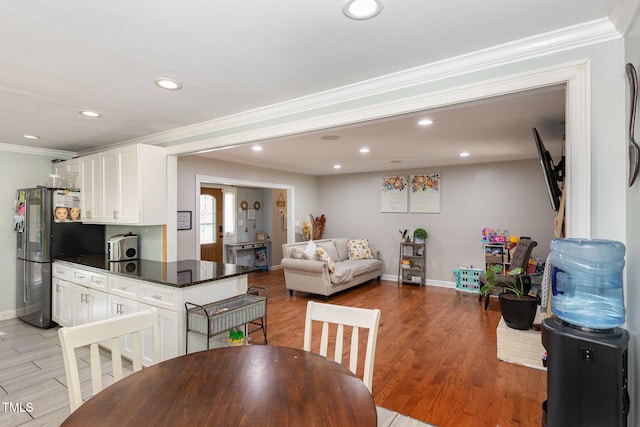 dining space with light hardwood / wood-style floors and crown molding