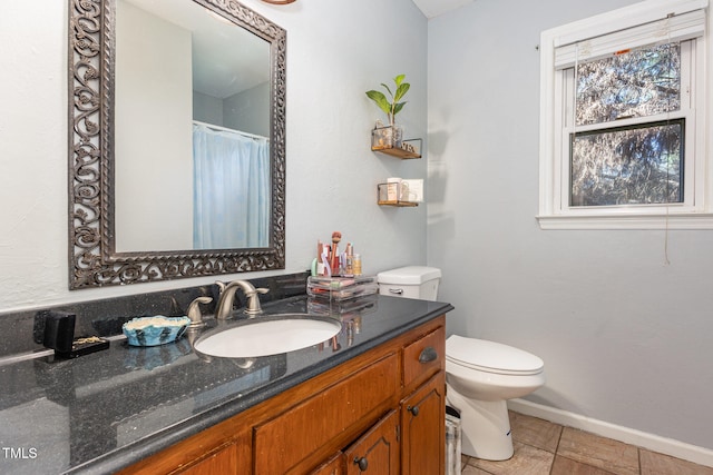 bathroom with tile patterned flooring, vanity, and toilet