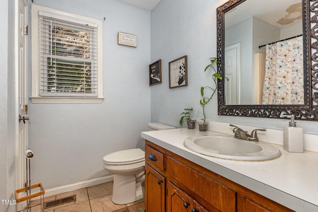 bathroom featuring toilet, vanity, and tile patterned floors