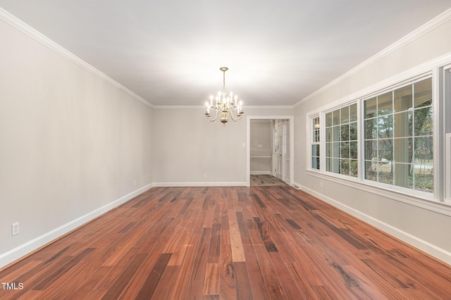 spare room with wood-type flooring, crown molding, and an inviting chandelier