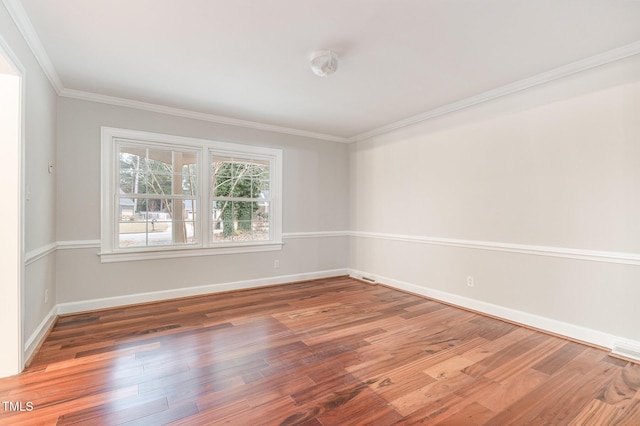 empty room with hardwood / wood-style floors and ornamental molding