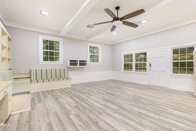 empty room with ceiling fan, light hardwood / wood-style flooring, and beamed ceiling