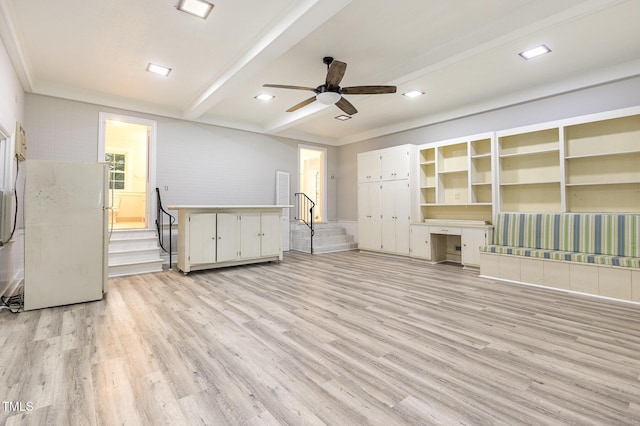 unfurnished living room with beamed ceiling, ceiling fan, ornamental molding, and light hardwood / wood-style floors