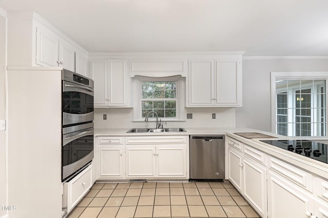 kitchen with ornamental molding, appliances with stainless steel finishes, sink, and white cabinets