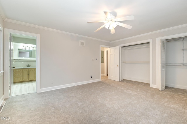 unfurnished bedroom with light carpet, two closets, and crown molding