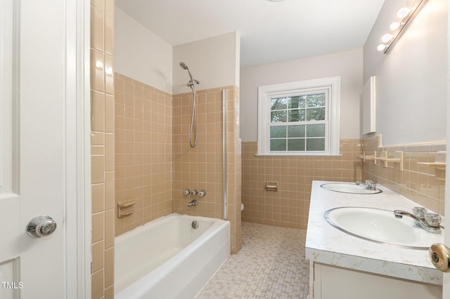 bathroom with vanity, tile walls, and tiled shower / bath