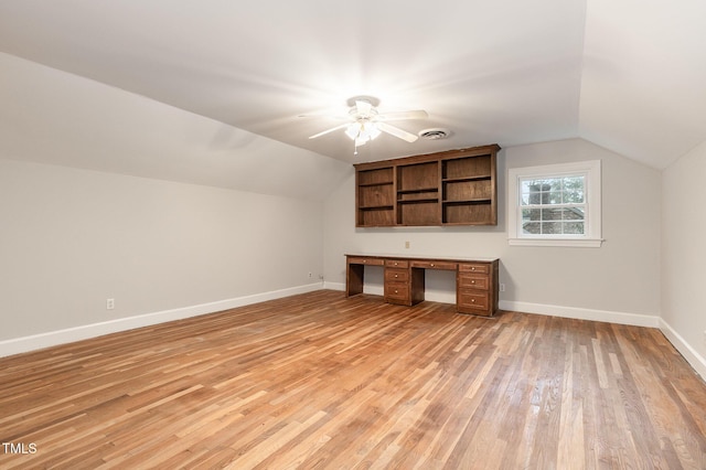 bonus room featuring built in desk, light hardwood / wood-style floors, ceiling fan, and vaulted ceiling