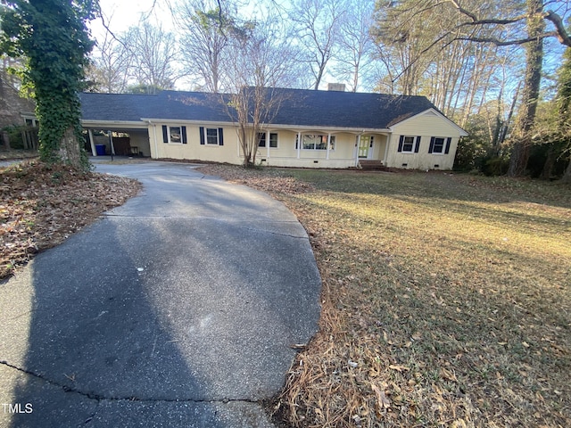 single story home featuring a carport, a porch, and a front lawn