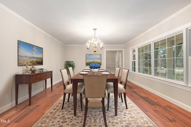 dining area featuring wood-type flooring, ornamental molding, and a notable chandelier