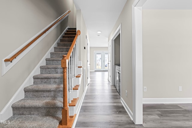 stairs featuring french doors and hardwood / wood-style flooring