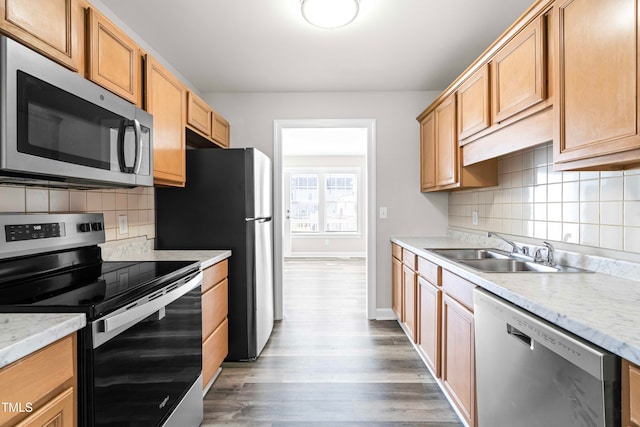 kitchen featuring decorative backsplash, sink, wood-type flooring, and stainless steel appliances