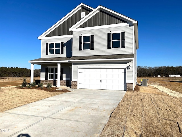 craftsman inspired home featuring cooling unit and a garage