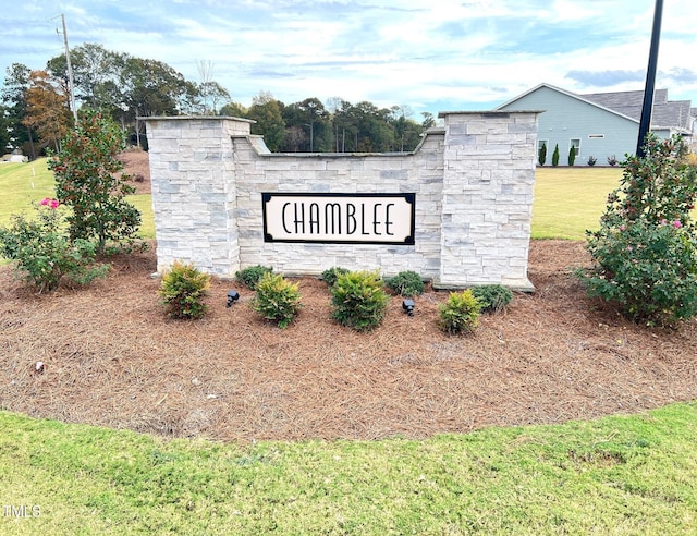 community / neighborhood sign featuring a yard