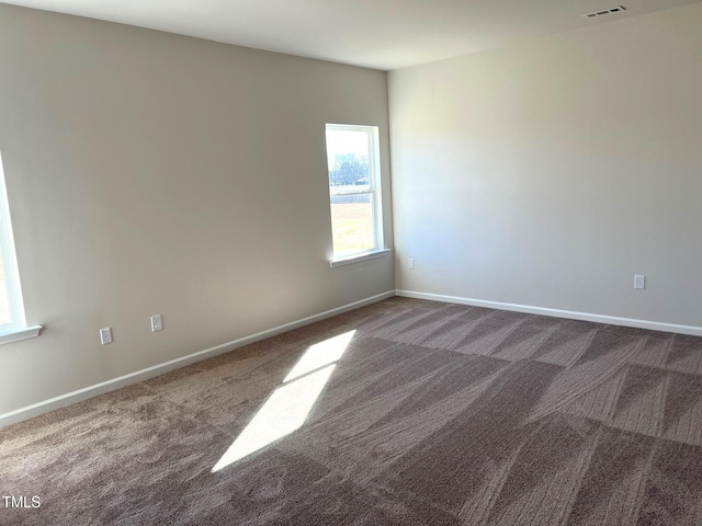 unfurnished room with dark colored carpet