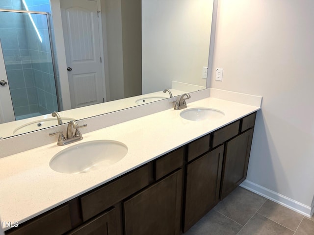 bathroom with tile patterned flooring, vanity, and walk in shower