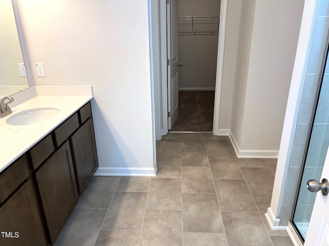 bathroom featuring vanity, tile patterned flooring, and a shower with door