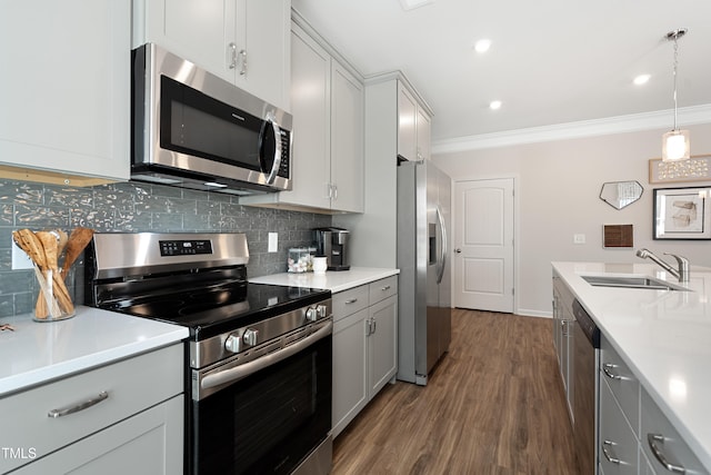 kitchen featuring sink, crown molding, tasteful backsplash, pendant lighting, and stainless steel appliances